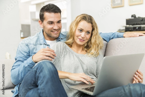 Obraz Young couple making the most of new technologies in their house