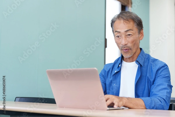 Fototapeta ノートパソコンを使い驚くシニア男性