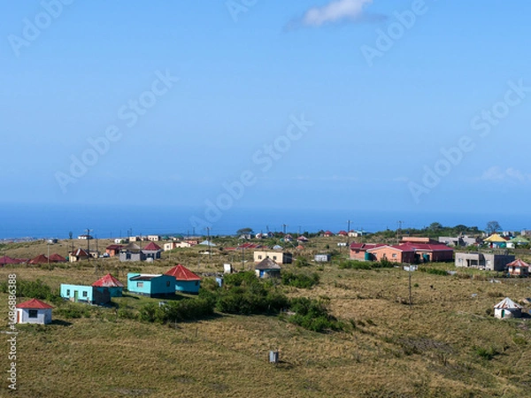 Fototapeta Houses of communities in rural Transkei, South Africa, on hills, surrounded by yellow grasslands which is used for grazing by cattle
