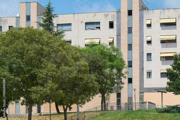 Fototapeta Modern apartment building with trees and green spaces.