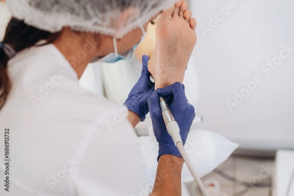 Obraz Visitor is sitting, feet getting peeled. Podiatrist with client in clinic