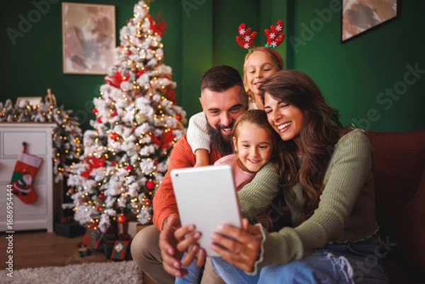 Fototapeta Family having fun taking selfies by the Christmas tree