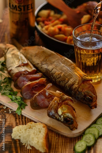Obraz Smoked Baikal Omul on the wooden table whith a glass of beer. Rustic style, organic food.