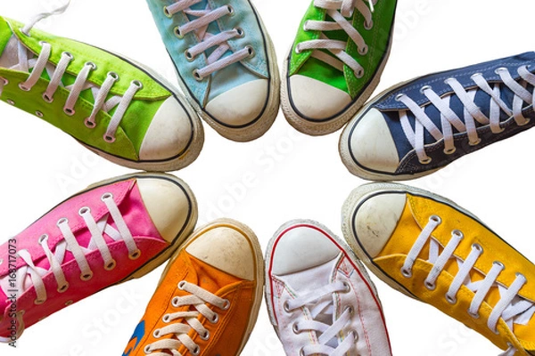 Fototapeta Colorful shoes on white background. Cool youth colorful white yellow green blue black orange gym shoes standing in circle on white background. with copy place top view.