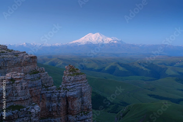 Fototapeta panoramic view of the Bolshoy Bermamyt plateau, with the snow-capped peaks of Mount Elbrus in the background, in early morning, at daytime, Stavropol Krai, Russia