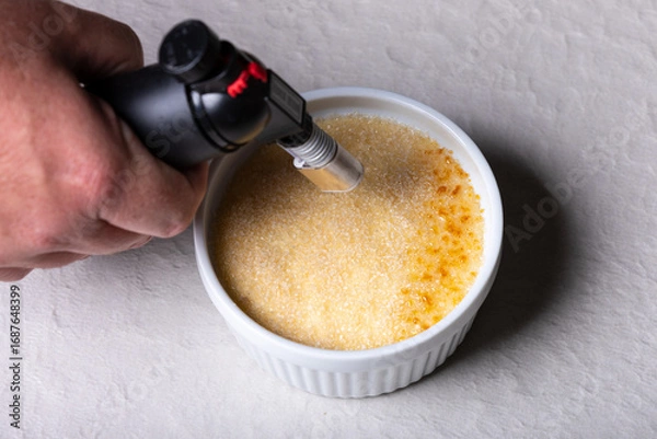 Obraz Caramelizing Crème Brûlée with Kitchen Torch