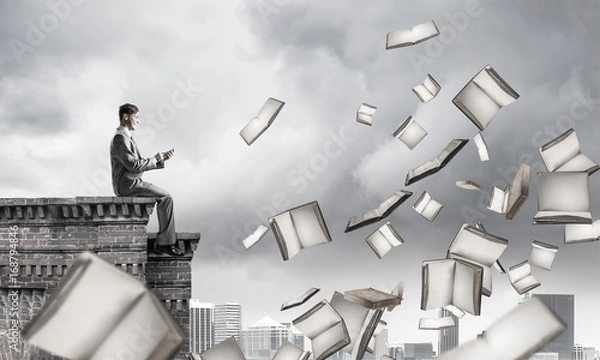 Fototapeta Man using smartphone and many books flying in air