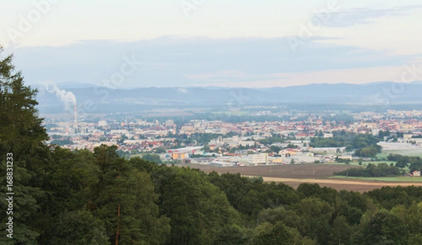 Fototapeta Ceske Budejovice in morning fog with city smoke and trees in left, Czech landscape