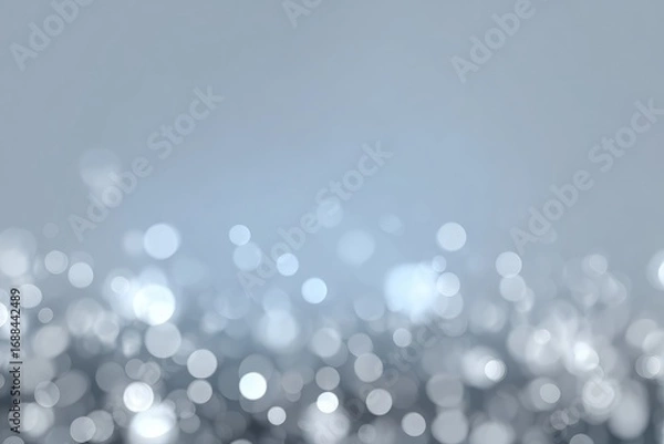 Fototapeta Abstract background features sparkling bokeh lights in grayscale, with a soft gradient fade to light blue at the top, evoking a dreamy or festive mood