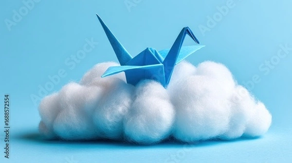 Obraz Origami crane rests peacefully atop a fluffy, cottony cloud against a soft blue backdrop, creating a serene and dreamlike miniature scene