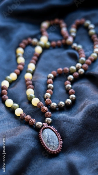 Fototapeta Mala beads made of rudraksha, calcite and pyrite with a fossilized coral pendant. High quality photo
