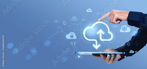 Fototapeta Cloud storage concept with hand interacting with digital upload and download icons above tablet on blue background in modern online data technology theme.