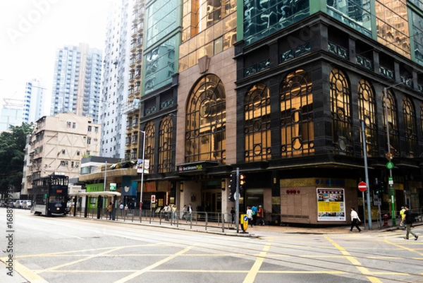 Fototapeta View landscape building skyscraper cityscape house of HongKong city and life lifestyle local chinese people walking on street with traffic light at traffic road on April 26, 2025 in Hong Kong, China