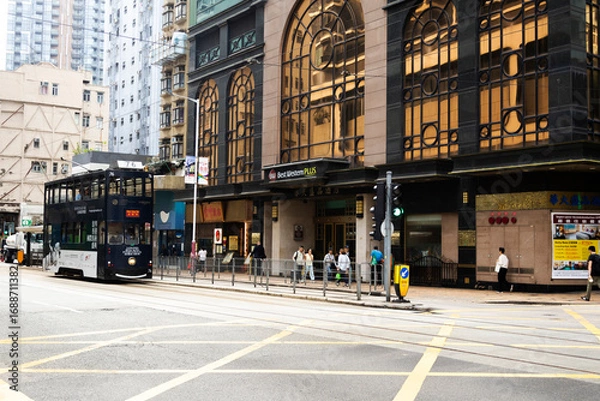 Fototapeta View landscape building skyscraper cityscape house of HongKong city and life lifestyle local chinese people walking on street with traffic light at traffic road on April 26, 2025 in Hong Kong, China