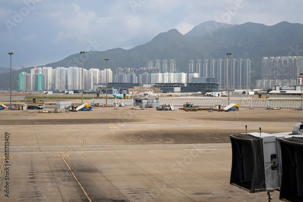 Fototapeta Exterior architecture buildings of Hongkong international airport and Aircraft boeing stop waiting passenger journey and local crew worker prepare plane on runway on April 26, 2025 in Hong Kong, China