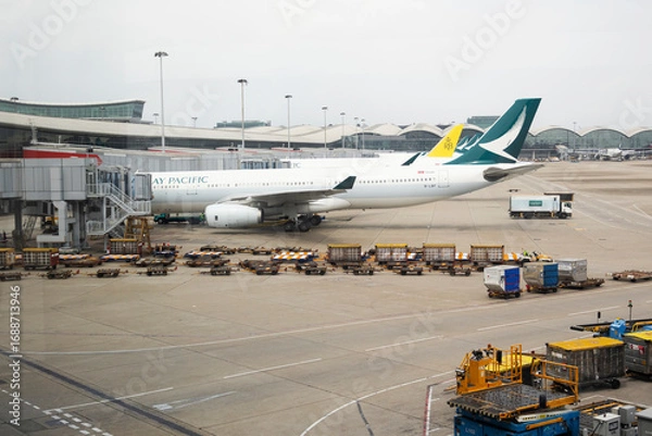 Fototapeta Exterior architecture buildings of Hongkong international airport and Aircraft boeing stop waiting passenger journey and local crew worker prepare plane on runway on April 26, 2025 in Hong Kong, China