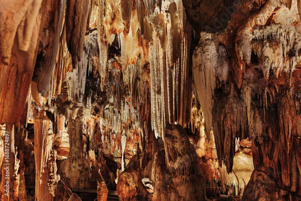 Obraz Panoramic view of stalactites and stalagmites in an artificially lit underground cave