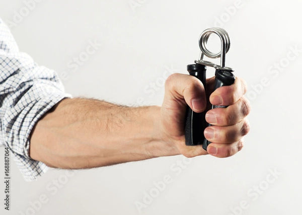 Obraz Man forcing together a strong spring