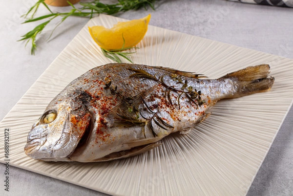 Fototapeta Baked dorada fish with spices