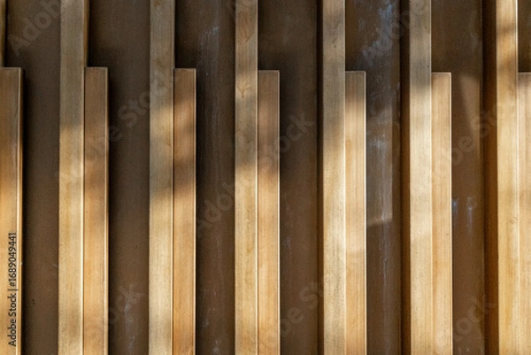 Fototapeta Abstract vertical wooden panels with shadows and light patterns