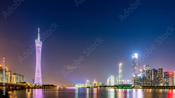 Obraz Night view of modern city skyline with tall skyscrapers and illuminated tower