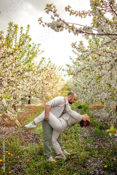 Obraz happy couple of adults on a walk in the spring park. family leisure. husband and wife walking in nature