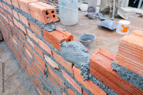 Fototapeta Construction of red brick walls for building structures