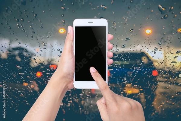 Fototapeta Woman using smartphone on blurred abstract city traffic backgroud