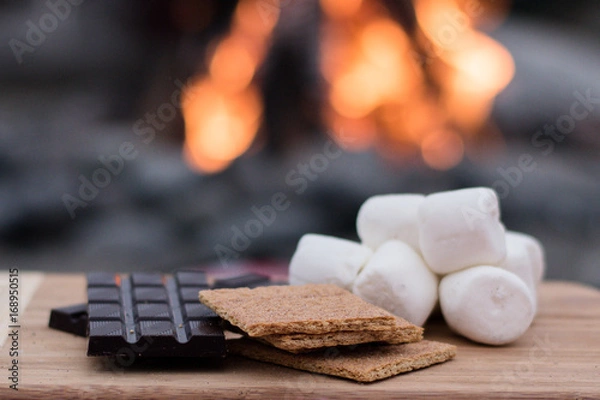Fototapeta Smores Ingredients at a Beach Bonfire with Chocolate, Marshmellow, and Graham Crackers with Room for Copy