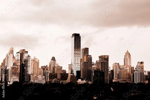 Fototapeta A modern city with towering skyscrapers under a dramatic cloudy skyThe sepia tone effect creates an urban and artistic atmosphere perfect for business architecture and cityscape themes Here in Bangkok