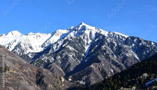 Fototapeta Snowy mountain range under a clear sky