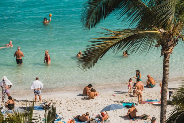 Obraz People enjoying the white sand beach and palm trees
