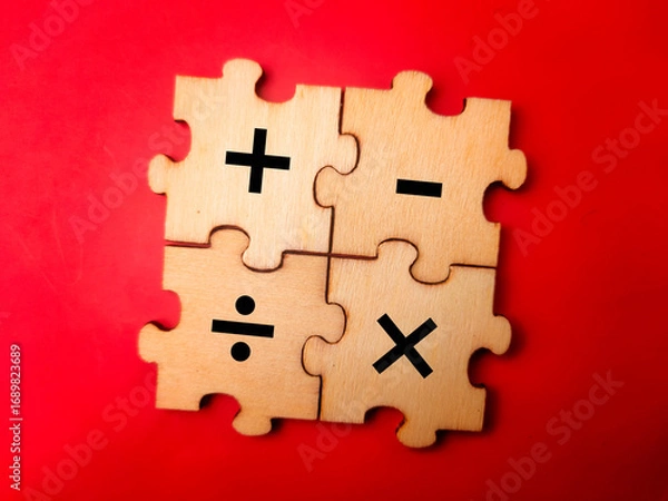Fototapeta The image shows four wooden puzzle pieces that together form a square. Each piece features a different basic arithmetic operation symbol