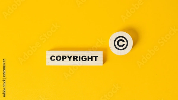 Fototapeta The word copyright and copyright symbol on wooden blocks. Concept of patenting. or copyright protection.