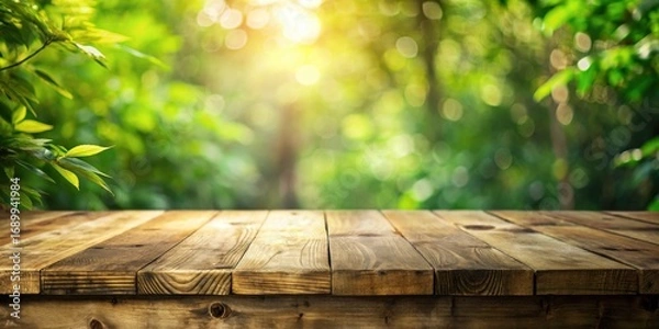 Fototapeta Rustic Wooden Tabletop Against a Vibrant, Sunlit, Lush Green Foliage Background, Ideal for Product Displays or Nature-Themed Compositions