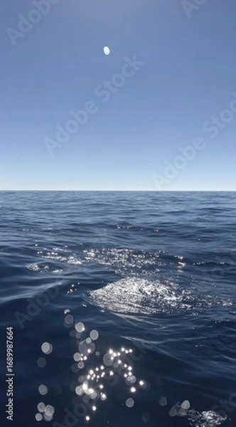 Obraz Serene ocean view calm water, distant horizon under clear blue sky with bright sun. Glimmering sunlight sparkles on gentle ripples