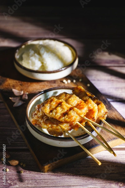 Fototapeta Moo ping grilled pork skewers with sticky rice on a restaurant table