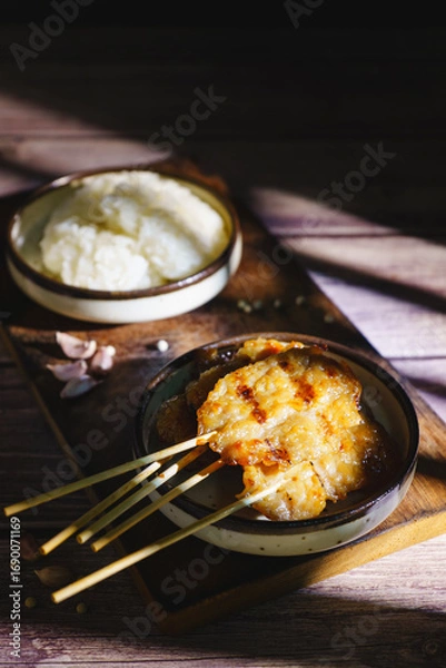 Fototapeta Moo ping grilled pork skewers with sticky rice on a restaurant table