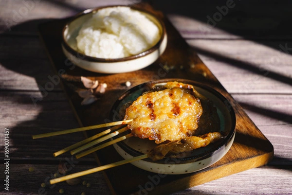 Fototapeta Moo ping grilled pork skewers with sticky rice on a restaurant table