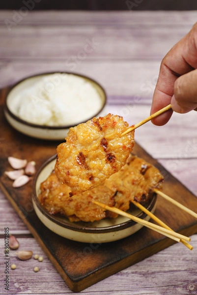 Fototapeta Moo ping grilled pork skewers with sticky rice on a restaurant table