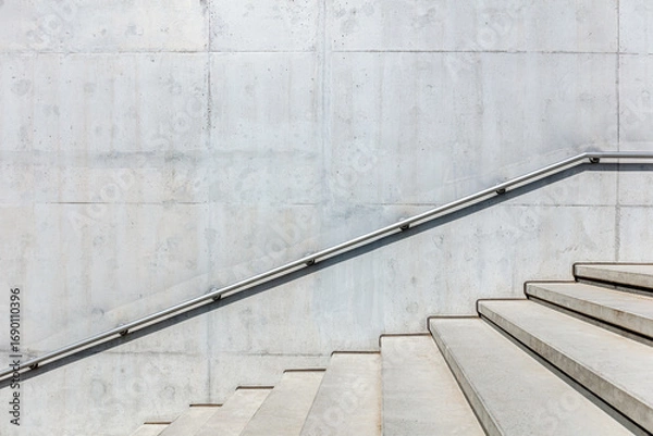 Fototapeta outdoor stairs with handrails on gray concrete wall. view on sunny bright day.