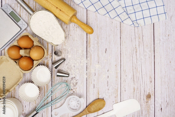 Fototapeta Homemade Dough Recipe (Eggs, flour, milk, sugar) and wooden kneading dough on a wooden table, view from above	
