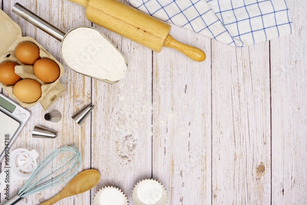 Fototapeta Homemade Dough Recipe (Eggs, flour, milk, sugar) and wooden kneading dough on a wooden table, view from above	
