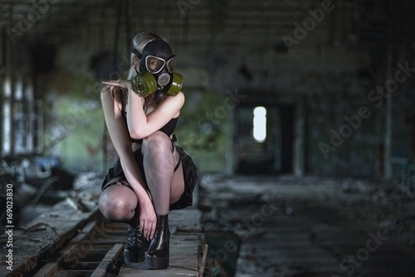 Obraz Beautiful, young girl post apocalypse girl sits in abandoned factory with gas mask