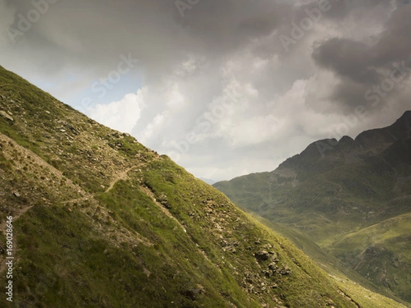 Fototapeta Track along a mountain  side with view across the valley and the mountains