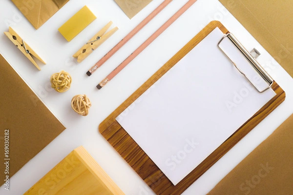 Fototapeta Top view of white table with pencil, notebook, brown paper ,paper bag and clipboard
