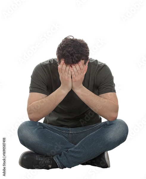 Fototapeta Stressed and depressed man seated on the floor covers face feeling desperate and anxious. Male full length portrait isolated on transparent background