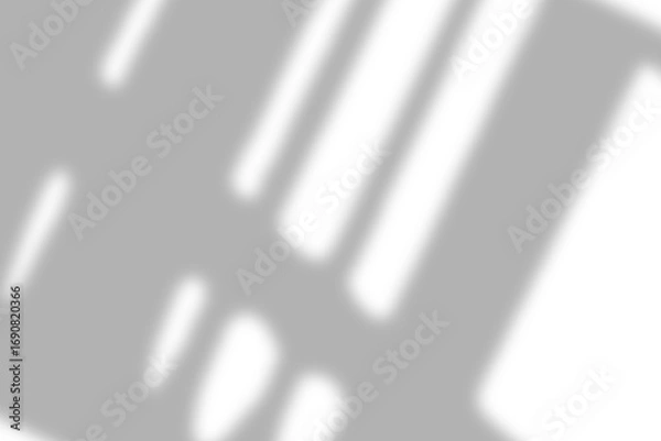 Fototapeta Light streaks from a window casting a gentle shadow on a bright white surface.