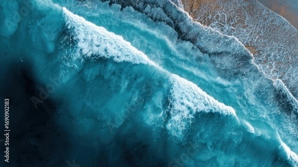 Fototapeta a view of a beach with a wave crashing