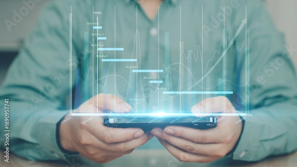 Fototapeta Businessman holding smartphone with holographic financial graph. Concept of digital finance, stock market, big data analytics, and modern business technology.